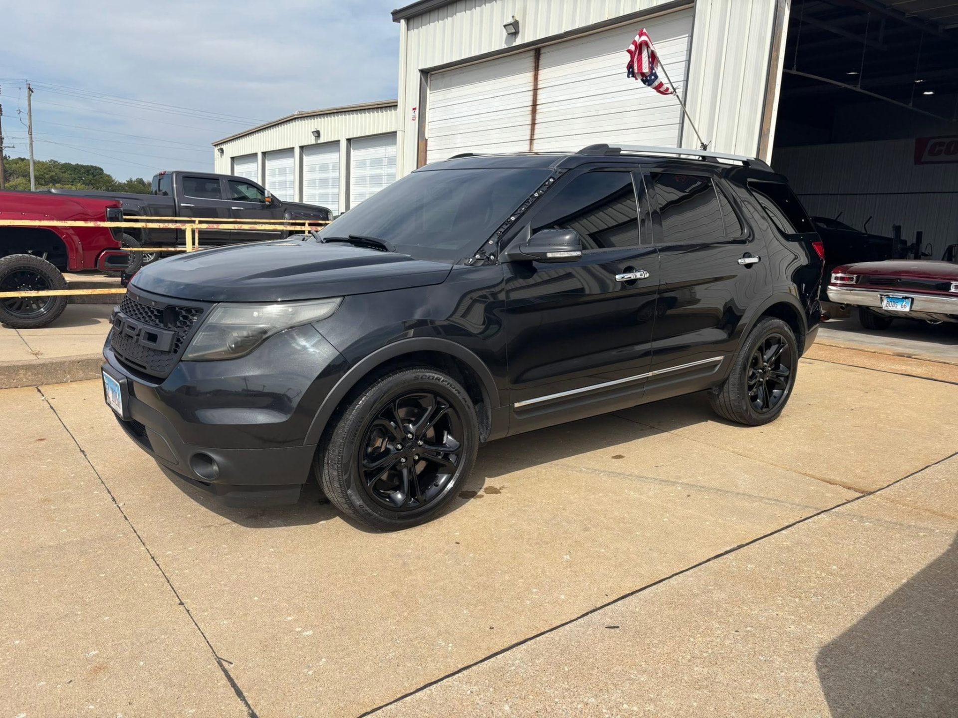 Black Ford Explorer with black wheels outside the shop