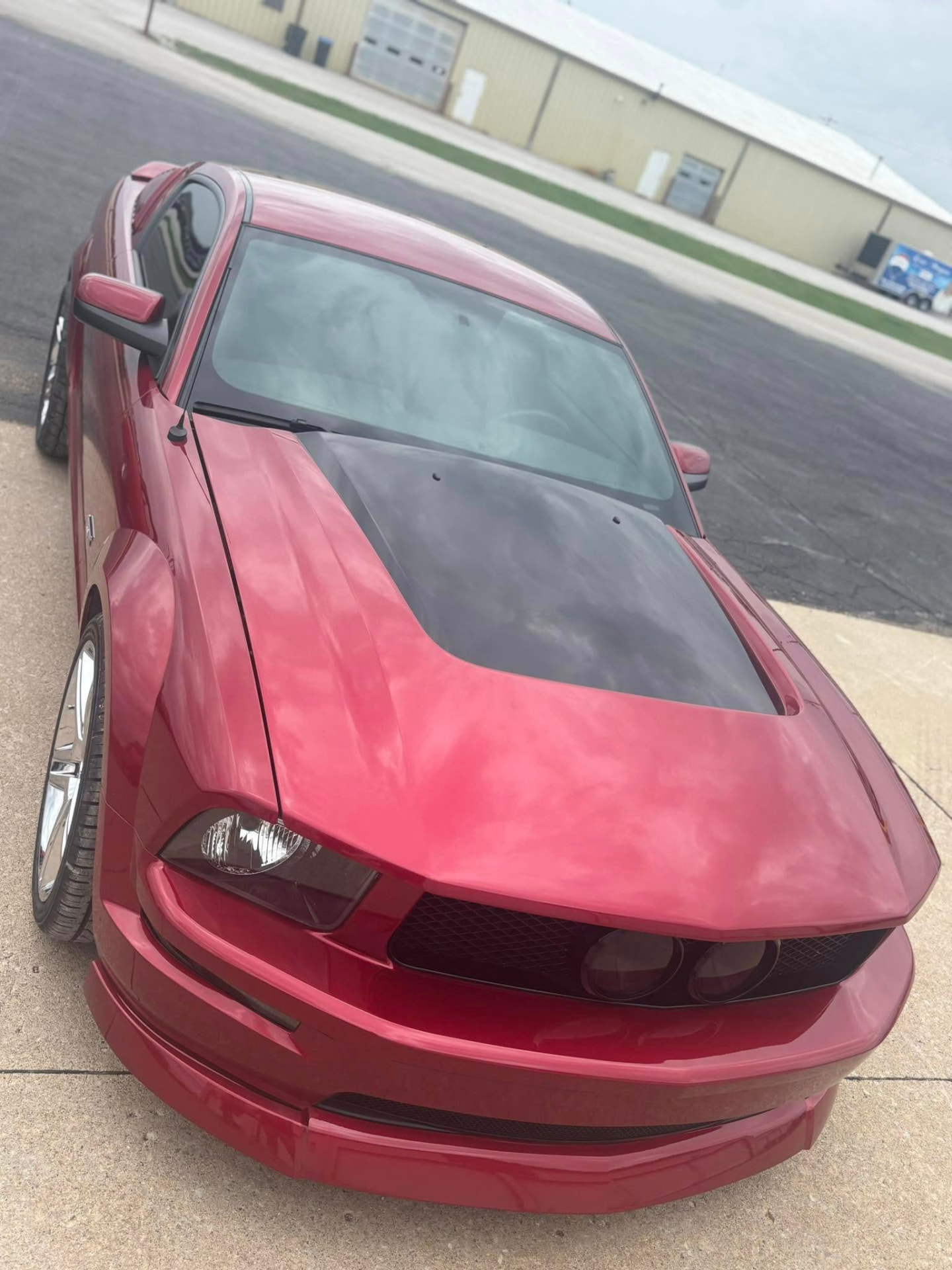 Red Mustang GT with blacked-out hood stripe